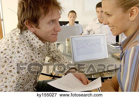 Stock Photo - Businessman and businesswoman, smiling in office. Fotosearch