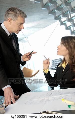 Businessman discussing with colleague in office View Large Photo Image Stock Image - Businessman discussing with colleague in office. Fotosearch