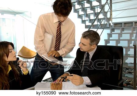 Stock Image - Businessman in discussion with colleagues in office. Fotosearch
