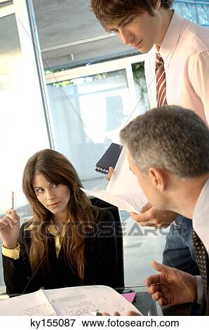 Businessman in discussion with colleagues in office View Large Photo Image Stock Photo - Businessman in discussion with colleagues in office. Fotosearch