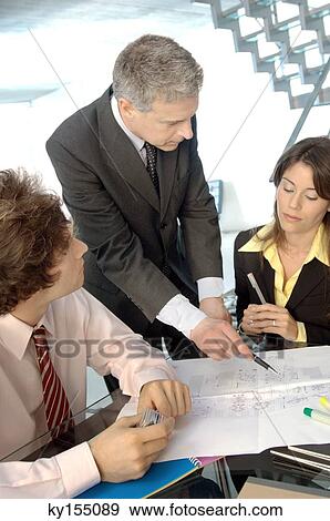 Stock Photo - Businessman in discussion with colleagues in office. Fotosearch