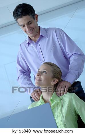 Businessman massaging businesswoman, smiling View Large Photo Image Stock Image - Businessman massaging businesswoman, smiling. Fotosearch