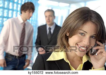 Stock Image - Businesswoman using mobile phone, smiling. Fotosearch