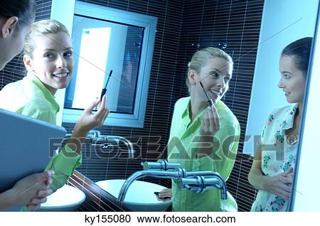 Stock Image - Businesswomen in washroom. Fotosearch