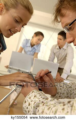 Young man and woman operating mobile phone View Large Photo Image Picture - Young man and woman operating mobile phone. Fotosearch