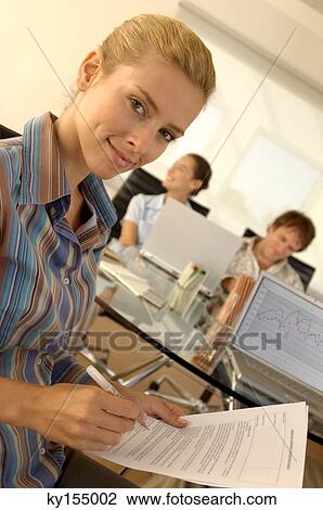Young woman holding pen and document, portrait View Large Photo Image Stock Image - Young woman holding pen and document, portrait. Fotosearch