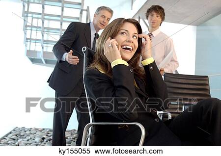 Stock Photography - Young woman using mobile phone, smiling. Fotosearch