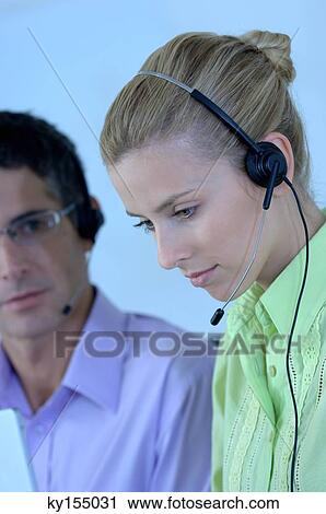 Stock Image - Young woman wearing headset, close-up. Fotosearch