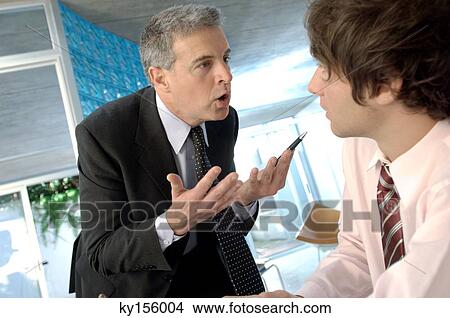Businessman discussing with colleague in office View Large Photo Image Picture - Businessman discussing with colleague in office. Fotosearch