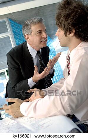 Businessman discussing with colleague in office View Large Photo Image Stock Image - Businessman discussing with colleague in office. Fotosearch