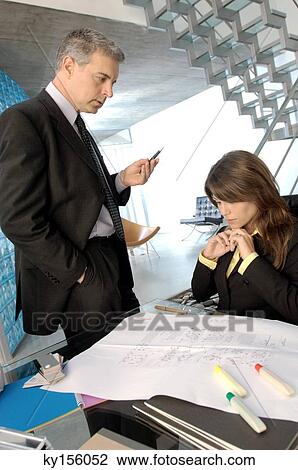 Businessman discussing with colleague in office View Large Photo Image Stock Image - Businessman discussing with colleague in office. Fotosearch