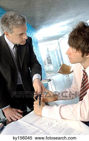 Businessman discussing with colleague in office View Large Photo Image Stock Photography - Businessman discussing with colleague in office. Fotosearch