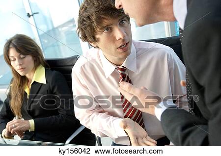 Businessman discussing with colleagues in office View Large Photo Image Stock Image - Businessman discussing with colleagues in office. Fotosearch