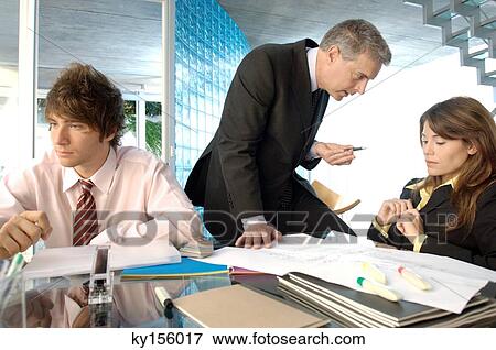 Businessman discussing with colleagues in office View Large Photo Image Stock Photo - Businessman discussing with colleagues in office. Fotosearch
