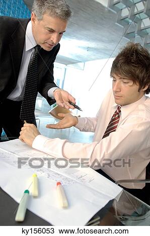 Businessman in discussion with colleague in office View Large Photo Image Stock Image - Businessman in discussion with colleague in office. Fotosearch