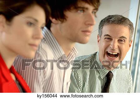 Businessman laughing in office, close-up, portrait View Large Photo Image Picture - Businessman laughing in office, close-up, portrait. Fotosearch