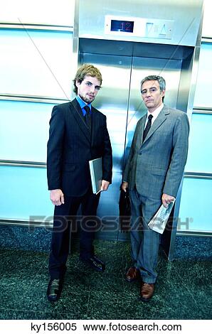 Stock Photography - Businessmen waiting for elevator, portrait. Fotosearch