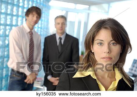 Businesswoman in office with colleagues in background View Large Photo Image Stock Photography - Businesswoman in office with colleagues in background. Fotosearch