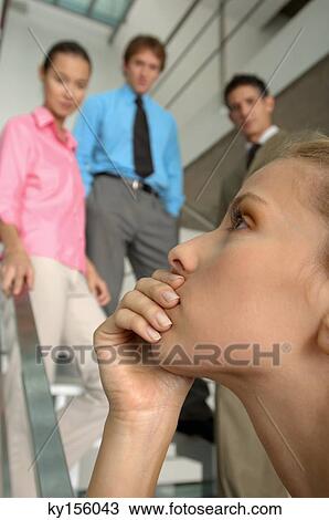 Businesswoman with colleagues standing in background View Large Photo Image Stock Image - Businesswoman with colleagues standing in background. Fotosearch