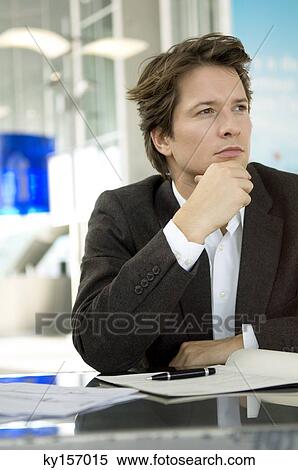 Businessman sitting at a desk and thinking View Large Photo Image Stock Photography - Businessman sitting at a desk and thinking. Fotosearch