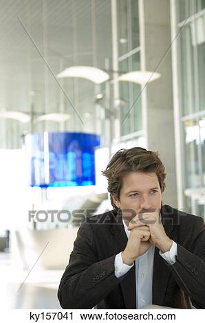 Businessman sitting in an office with his hands clasped View Large Photo Image Stock Image - Businessman sitting in an office with his hands clasped. Fotosearch
