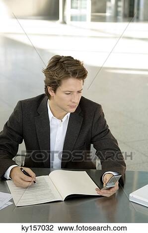 Businessman text messaging with a mobile phone View Large Photo Image Stock Image - Businessman text messaging with a mobile phone. Fotosearch