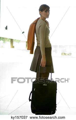 Businesswoman standing with her luggage at an airport View Large Photo Image Stock Photo - Businesswoman standing with her luggage at an airport. Fotosearch