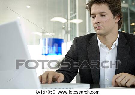 Close-up of a businessman using a laptop in an office View Large Photo Image Stock Image - Close-up of a businessman using a laptop in an office. Fotosearch