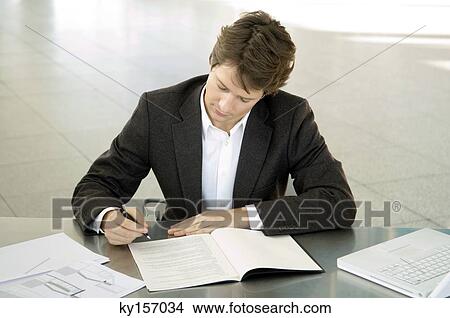 Close-up of a businessman working at a desk View Large Photo Image Picture - Close-up of a businessman working at a desk. Fotosearch