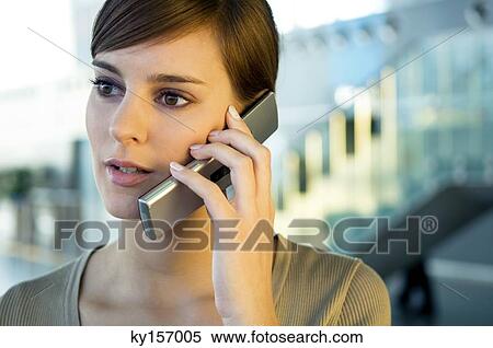 Close-up of a young woman talking on a mobile phone View Large Photo Image Stock Photography - Close-up of a young woman talking on a mobile phone. Fotosearch