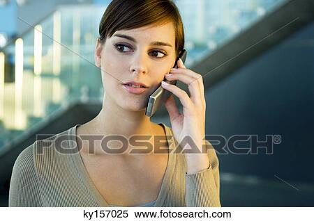Close-up of a young woman talking on a mobile phone View Large Photo Image Stock Photography - Close-up of a young woman talking on a mobile phone. Fotosearch