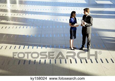 Businessman and a businesswoman holding documents View Large Photo Image Picture - Businessman and a businesswoman holding documents. Fotosearch