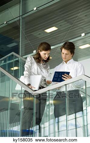 Businessman and a businesswoman looking at the documents View Large Photo Image Stock Photography - Businessman and a businesswoman looking at the documents. Fotosearch