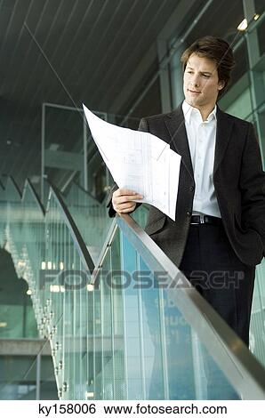 Businessman looking at a blueprint View Large Photo Image Stock Photograph - Businessman looking at a blueprint. Fotosearch