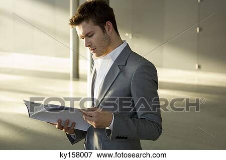 Stock Photo - Businessman reading a magazine. Fotosearch