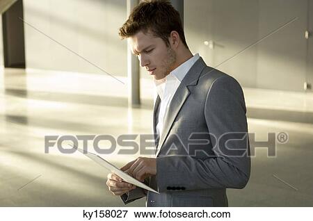 Businessman reading a magazine View Large Photo Image Stock Photo - Businessman reading a magazine. Fotosearch