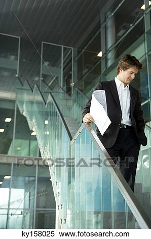 Businessman standing on a staircase with a blueprint View Large Photo Image Stock Photography - Businessman standing on a staircase with a blueprint. Fotosearch