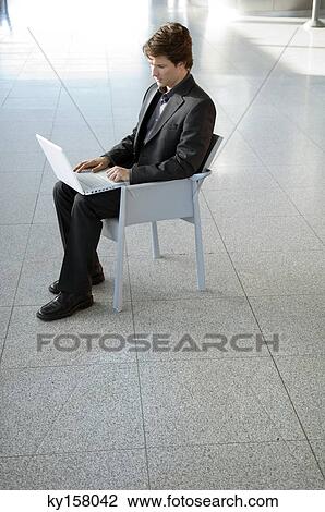 Businessman working on a laptop View Large Photo Image Stock Image - Businessman working on a laptop. Fotosearch