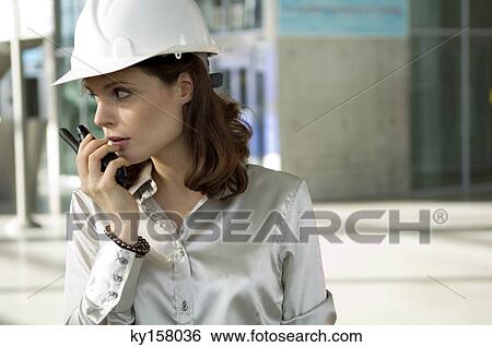 Stock Photograph - Close-up of a young woman talking on a walkie-talkie. Fotosearch