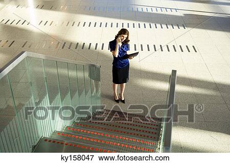 High angle view of a businesswoman talking on a mobile phone View Large Photo Image Stock Photo - High angle view of a businesswoman talking on a mobile phone. Fotosearch