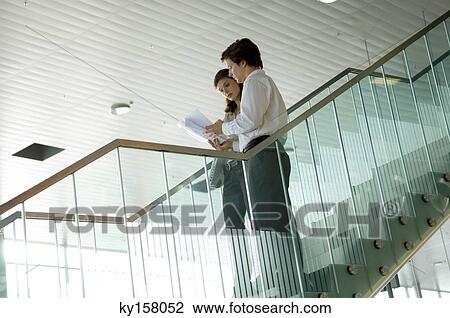 Low angle view of a businessman and a businesswoman looking at a blueprint View Large Photo Image Stock Image - Low angle view of a businessman and a businesswoman looking at a blueprint. Fotosearch