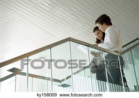 Low angle view of a businessman and a businesswoman looking at a blueprint View Large Photo Image Stock Photo - Low angle view of a businessman and a businesswoman looking at a blueprint. Fotosearch