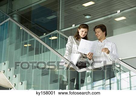 Low angle view of a businessman showing a blueprint to a businesswoman View Large Photo Image Stock Image - Low angle view of a businessman showing a blueprint to a businesswoman. Fotosearch