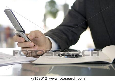 Mid section view of a businessman using a mobile phone View Large Photo Image Stock Image - Mid section view of a businessman using a mobile phone. Fotosearch