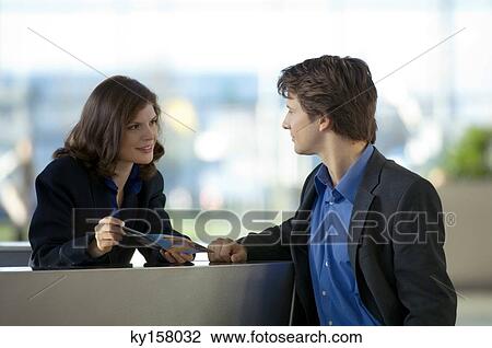 Receptionist showing a brochure to a businessman View Large Photo Image Stock Image - Receptionist showing a brochure to a businessman. Fotosearch