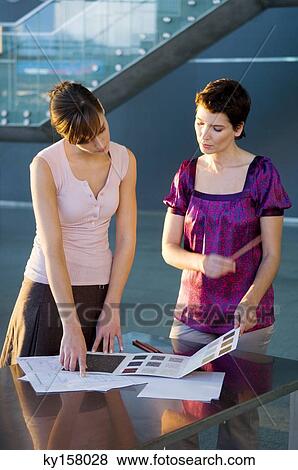 Two interior designers discussing on a color swatch View Large Photo Image Stock Photo - Two interior designers discussing on a color swatch. Fotosearch