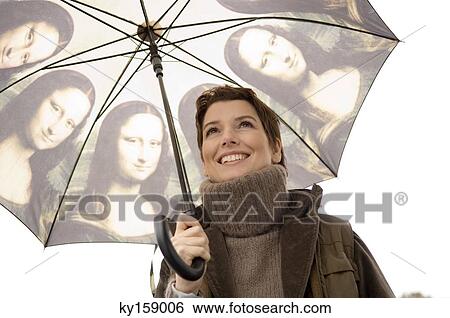 Close-up of a mid adult woman holding an umbrella View Large Photo Image Stock Photograph - Close-up of a mid adult woman holding an umbrella. Fotosearch
