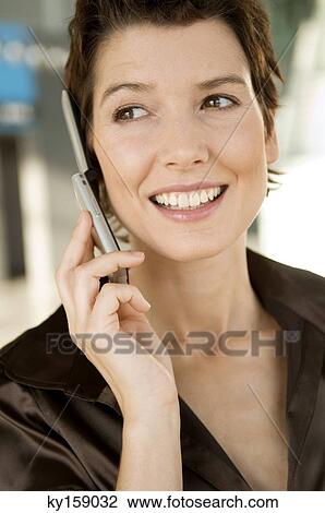 Close-up of a mid adult woman talking on a mobile phone View Large Photo Image Stock Image - Close-up of a mid adult woman talking on a mobile phone. Fotosearch