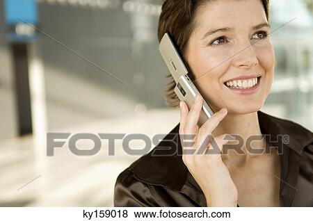 Close-up of a mid adult woman talking on a mobile phone View Large Photo Image Stock Photo - Close-up of a mid adult woman talking on a mobile phone. Fotosearch