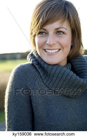 Close-up of a young woman smiling View Large Photo Image Stock Photograph - Close-up of a young woman smiling. Fotosearch